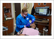 Dental hygienist performing a preventive teeth cleaning with digital charting on screen at Roman Dental Arts in Hackensack, NJ