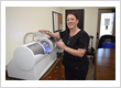 Dental team member operating the CEREC MC XL milling machine for same-day ceramic crown restorations at Roman Dental Arts in Hackensack, NJ