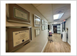 Hallway of Orlando dentist office Lake Lucerne Cosmetic and Implant Dentistry  adorned with framed diplomas and certificates, featuring a polished wood floor and modern decor